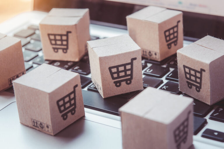 mini boxes with shopping carts on them sitting on a laptop keyboard