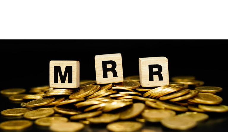 blocks with letters MRR on a pile of gold coins