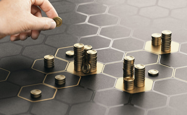 hand stacking coins on a game board