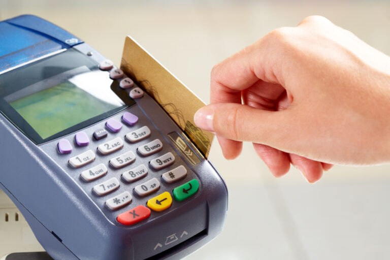 hand swiping a credit card on a card reader