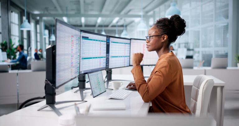 An accounts receivable professional looking at multiple computer monitors